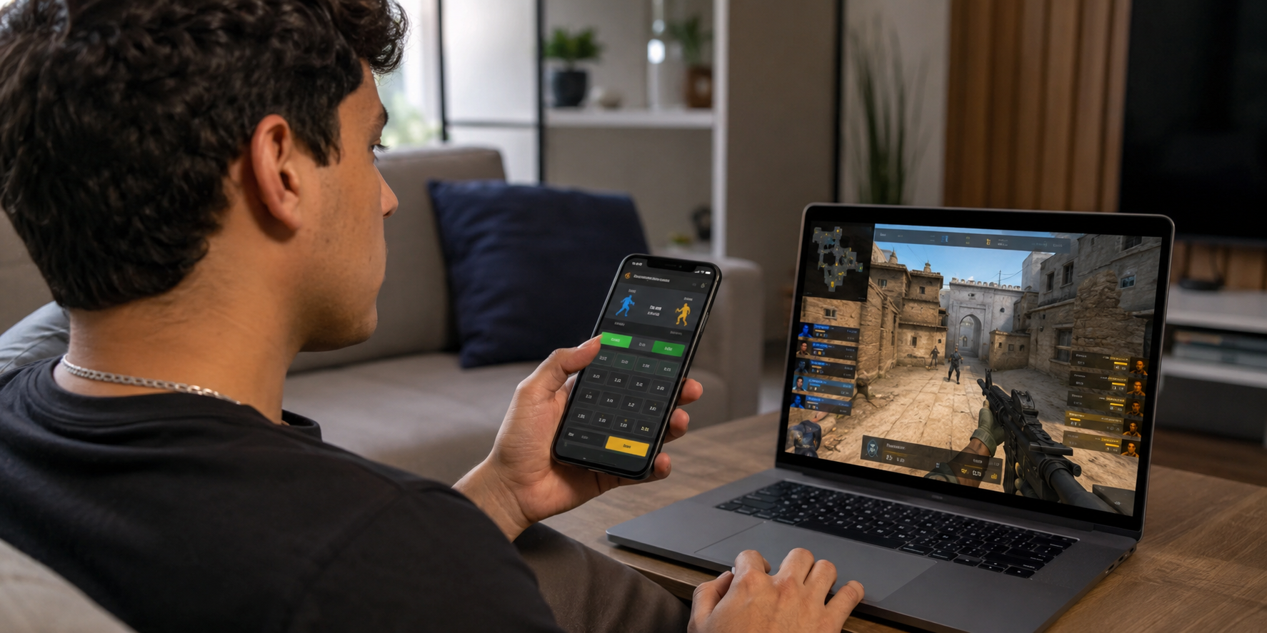 Hombre hace una apuesta en el teléfono mientras mira un partido de Counter-Strike en el portátil